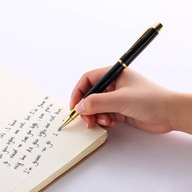 a hand writing with a pen on a notebook